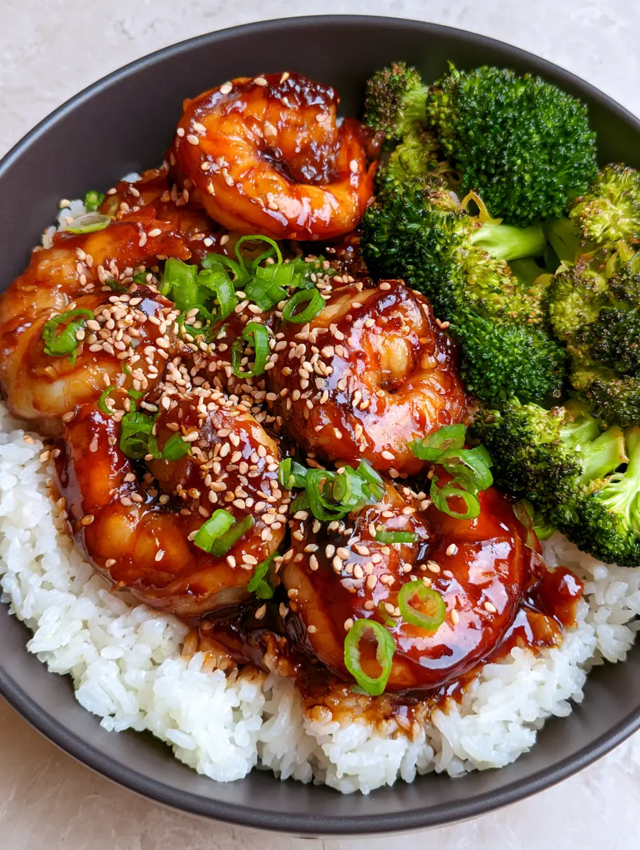 Handheld photo of Teriyaki Shrimp Rice Bowls showing the thick dark glaze and bright green broccoli florets. (Teriyaki Shrimp Rice Bowls)