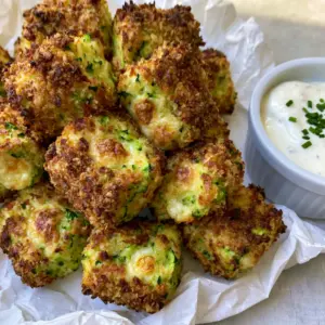 Top-down view of textured zucchini tots with visible green zucchini and panko crust. (zucchini tots)